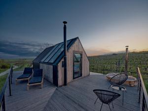 une petite maison en bois avec des chaises sur une terrasse dans l'établissement CAMPY ECO HOUSE • EGER, à Ostoros