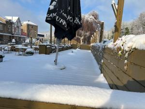 parasol na śniegu obok płotu w obiekcie Hotel Val De La Cascade w mieście Stavelot