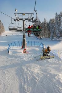 un groupe de personnes sur une remontée mécanique dans la neige dans l'établissement Domki na Polach Piwniczna-Zdrój, à Piwniczna-Zdrój