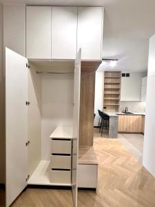 Zimmer mit einem Schrank mit weißen Schränken und einer Küche in der Unterkunft Apartament Zdrojowy Zakątek in Busko-Zdrój