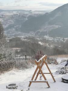 une personne debout sur une échelle dans la neige dans l'établissement Domki na Polach Piwniczna-Zdrój, à Piwniczna-Zdrój