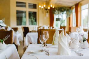 een eetkamer met witte tafels met glazen en servetten bij REGIOHOTEL Naturresort Ilsenburg in Ilsenburg