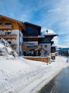 um grande edifício na neve em frente a uma estrada em Das Grünholz Aparthotel em Mühlbach am Hochkönig