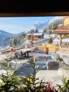 uma vista a partir de uma janela de um resort com uma mesa e cadeiras em Das Grünholz Aparthotel em Mühlbach am Hochkönig