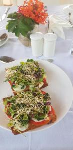 ein weißer Teller mit Salat auf dem Tisch in der Unterkunft The Meadows Resort and Spa in Aurangabad