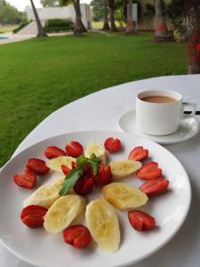 einen Obstteller und eine Tasse Kaffee auf dem Tisch in der Unterkunft The Meadows Resort and Spa in Aurangabad