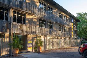 un edificio de ladrillo con dos macetas delante de él en N1 Hotel & Campsite Victoria Falls, en Victoria Falls