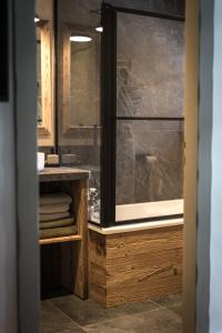 La salle de bains est pourvue d'une fenêtre et d'un lavabo avec des serviettes. dans l'établissement Hôtel Restaurant La Ferme de Cupelin, à Saint-Gervais-les-Bains