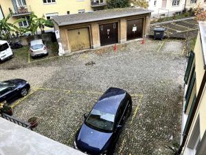 um carro estacionado num parque de estacionamento em frente a um edifício em Central & modern penthouse-studio with balcony & air-condition em Zurique