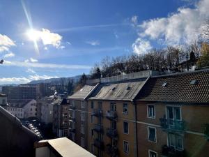 uma vista para uma cidade com edifícios e o sol em Central & modern penthouse-studio with balcony & air-condition em Zurique