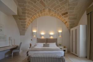 een slaapkamer met een groot bed en een stenen plafond bij Baglioni Masseria Muzza in Otranto