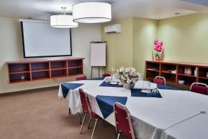 uma sala de conferências com uma mesa e um ecrã de projecção em Hotel Le Versailles em Saint-Sauveur-des-Monts