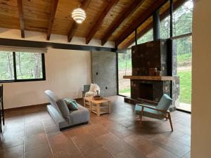 sala de estar con chimenea de piedra y sillas en Las Nubes, en Mazamitla