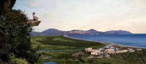 uma pessoa sentada em cima de uma rocha com vista para uma massa de água em Hilton Dalaman Sarigerme Resort & Spa em Dalaman