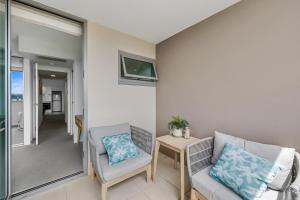 a living room with two chairs and a table at Nova Mooloolaba Beach Apartments in Mooloolaba