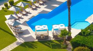 uma vista sobre uma piscina com espreguiçadeiras e uma piscina em San Giovanni Beach Resort and Suites em Lefkada Town