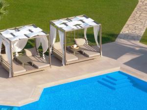 uma vista superior de dois gazebos e uma piscina em San Giovanni Beach Resort and Suites em Lefkada Town