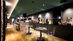 un restaurant avec un bar doté de chaises et de tables dans l'établissement Hotel Noir Blanc, à Shizuoka