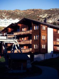 um edifício de madeira com uma ponte em frente em Boutique Hotel La Cabane em Bettmeralp