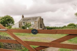 una valla de madera con una casa en el fondo en Kitts Cottage Redruth, en Redruth