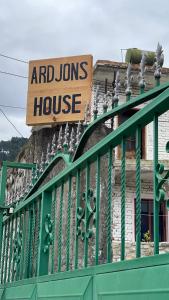 um sinal numa casa com uma cerca verde em Ardjon House em Berati