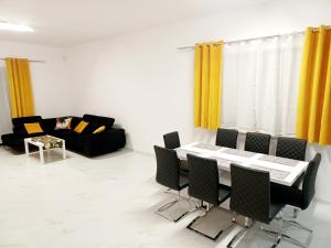 ein Wohnzimmer mit einem Tisch, Stühlen und einem Sofa in der Unterkunft AJP Exclusive House Szczecin in Stettin