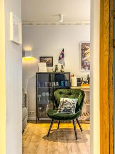 - un salon avec une chaise verte et une étagère dans l'établissement Enjoy Reykjavík Yellow Door Apartment, à Reykjavik