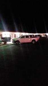 una limusina estacionada en un estacionamiento por la noche en Travel Inn Motel, en Canon City