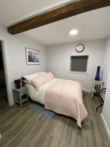 a bedroom with a bed and a clock on the wall at The Old Barn one bedroom apartment in Overton in Overton