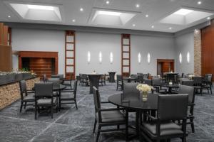 uma sala de jantar com mesas e cadeiras e uma lareira em Renaissance Indianapolis North Hotel em Carmel