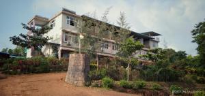 a house with a large tree stump in front of it at Viraz Valley in Gokarna