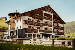 a large building with balconies on the side of it at Hotel Alpenrose in Arabba