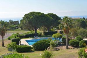 une piscine dans un jardin avec des arbres et des buissons dans l'établissement Résidence les Hameaux de Bocca del Oro, à Porto-Vecchio