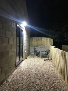 two chairs and a table on a patio at night at Springwood farm 