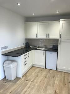 a kitchen with white cabinets and a counter top at Springwood farm 