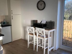 a kitchen with a table with chairs and a clock on the wall at Springwood farm 