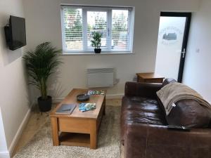 a living room with a brown leather couch and a coffee table at Springwood farm 