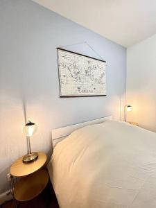 1 dormitorio con 1 cama y 1 mesa con lámpara en Le Quartz Blanc / Bourg-de-Péage, en Bourg-de-Péage