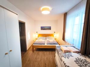 a bedroom with two beds and a window at Apartmány Lipno-Hory in Horní Planá