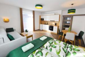 a living room with a white couch and a kitchen at Apartmány Lipno-Hory in Horní Planá