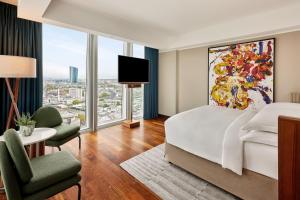 Habitación de hotel con cama y ventana grande en JW Marriott Hotel Frankfurt, en Frankfurt