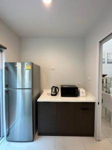 a kitchen with a stainless steel refrigerator and a microwave at MIQ_home901/Asok BTS/Resort Pool/12pax/1000MbWifi in Bangkok