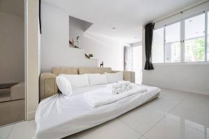 a white bedroom with a large white bed in a room at MIQ_home901/Asok BTS/Resort Pool/12pax/1000MbWifi in Bangkok