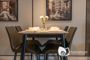 una mesa de comedor con sillas y flores. en Highpark Suites at Petaling Jaya, Kelana Jaya by Plush, en Petaling Jaya