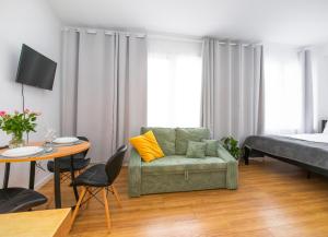 een woonkamer met een bank, een bed en een tafel bij Apartamenty Piastowska in Nysa