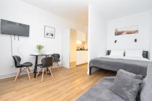 een slaapkamer met een bed en een tafel en stoelen bij Apartamenty Piastowska in Nysa