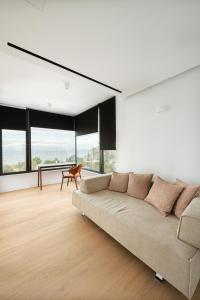 a living room with a couch and large windows at Elia Cove Luxury Villa with private Grand Pool in Korinthos