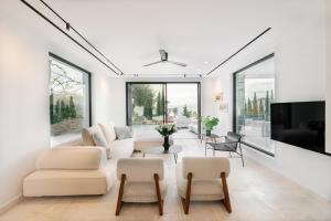 a living room with a couch and chairs and a tv at Elia Cove Luxury Villa with private Grand Pool in Korinthos