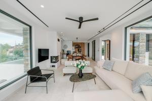 a living room with white furniture and large windows at Elia Cove Luxury Villa with private Grand Pool in Korinthos