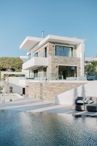 a house with a swimming pool in front of it at Elia Cove Luxury Villa with private Grand Pool in Korinthos